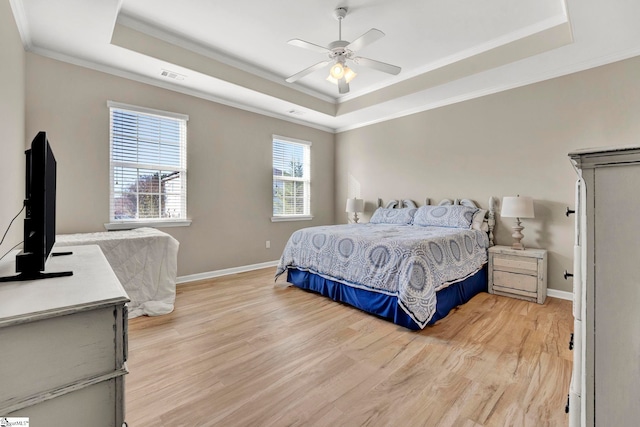 bedroom featuring a raised ceiling, ceiling fan, and crown molding