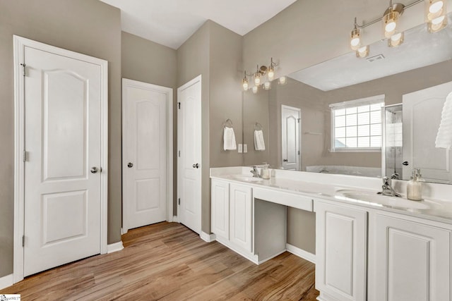 bathroom with hardwood / wood-style floors, vanity, and independent shower and bath