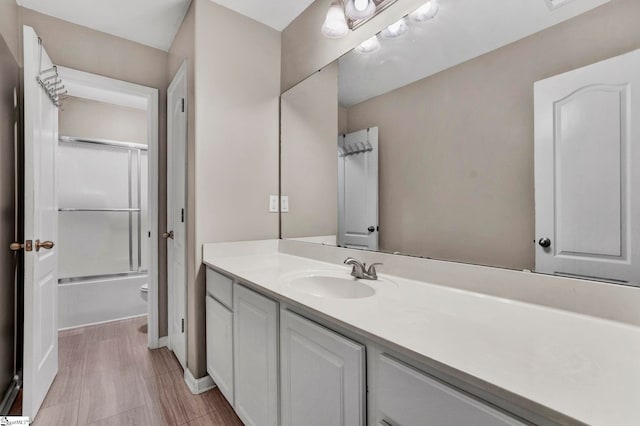 full bathroom with vanity, toilet, and enclosed tub / shower combo