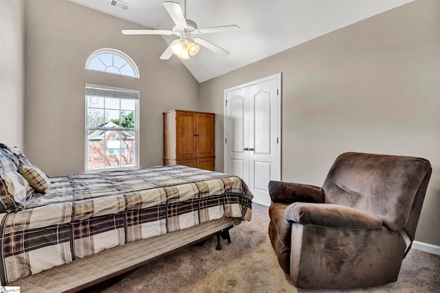 bedroom with ceiling fan, vaulted ceiling, light carpet, and a closet