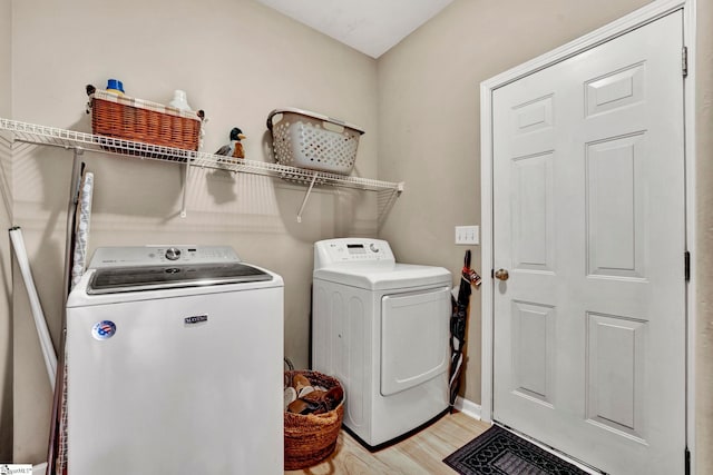 washroom with separate washer and dryer and light hardwood / wood-style floors