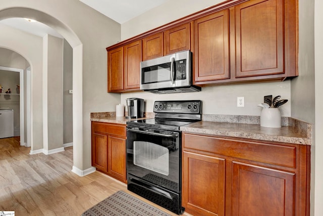 kitchen with black electric range oven and light wood-type flooring