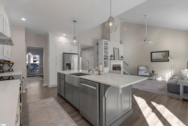 kitchen featuring appliances with stainless steel finishes, ceiling fan, sink, a center island with sink, and white cabinetry