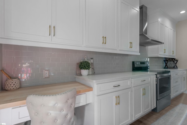 kitchen with white cabinets, decorative backsplash, wall chimney range hood, and stainless steel range with electric cooktop