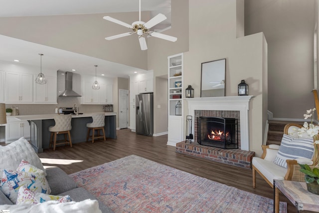 living room with ceiling fan, a fireplace, high vaulted ceiling, and dark hardwood / wood-style floors