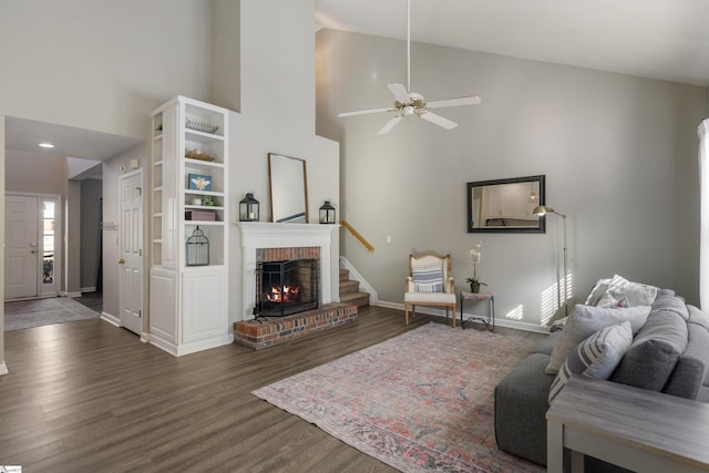 living room with ceiling fan, dark hardwood / wood-style flooring, a fireplace, and high vaulted ceiling