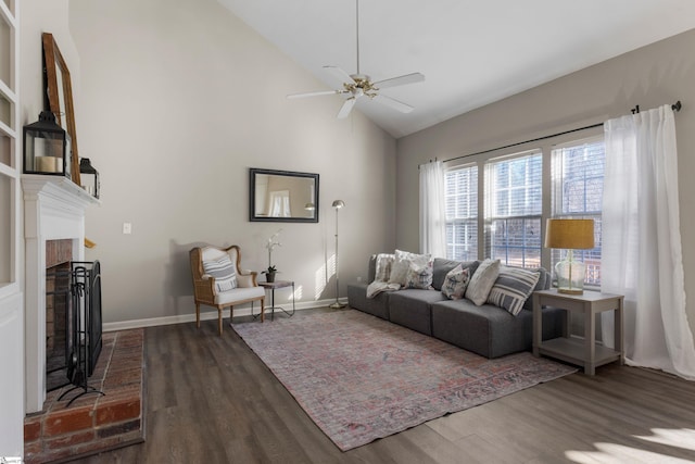 living room with dark hardwood / wood-style flooring, ceiling fan, a fireplace, and lofted ceiling