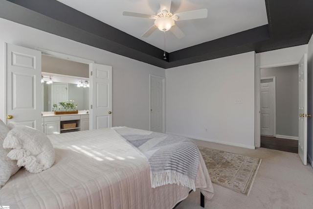 carpeted bedroom featuring a raised ceiling and ceiling fan