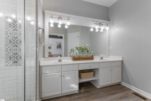 bathroom featuring vanity, a shower with shower door, and wood-type flooring