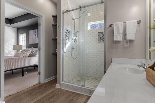 bathroom with hardwood / wood-style floors, vanity, and a shower with shower door