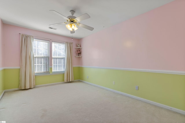 spare room with ceiling fan and carpet