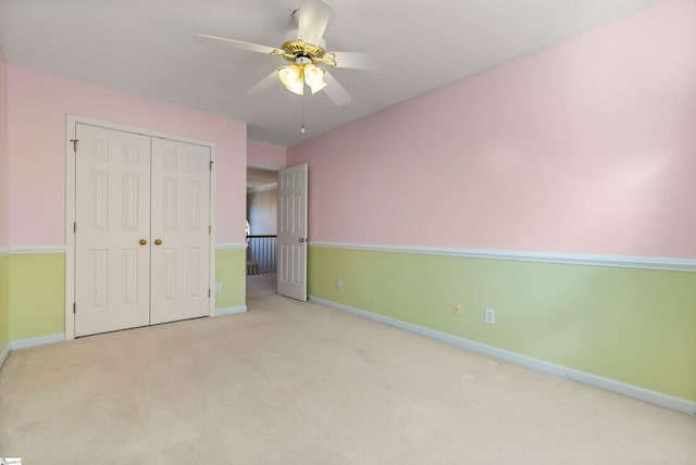 unfurnished bedroom with ceiling fan, a closet, and light colored carpet