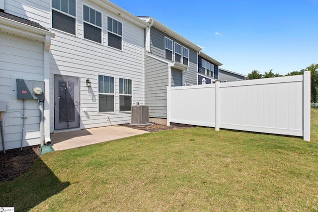 back of property with central air condition unit, a yard, and a patio