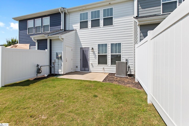 back of house featuring central AC, a patio area, and a yard