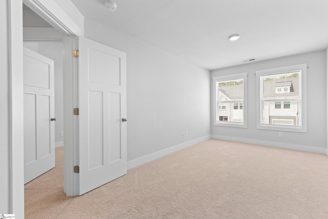 spare room featuring light colored carpet