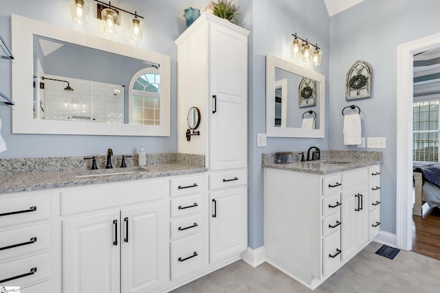 bathroom with tile patterned flooring, vanity, and walk in shower