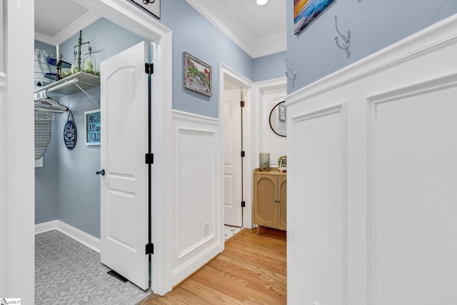 corridor featuring crown molding and light hardwood / wood-style flooring