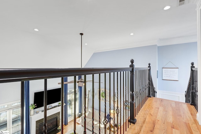 corridor featuring a wealth of natural light, crown molding, and hardwood / wood-style flooring