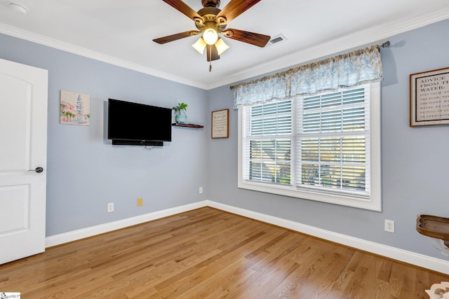 interior space featuring ceiling fan, light wood-type flooring, and ornamental molding