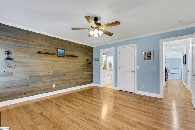 interior space featuring ornamental molding, light wood-type flooring, and wooden walls