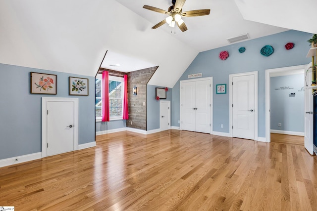 unfurnished living room with ceiling fan, light wood-type flooring, and lofted ceiling