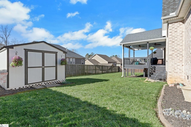 view of yard with ceiling fan, a shed, and a wooden deck