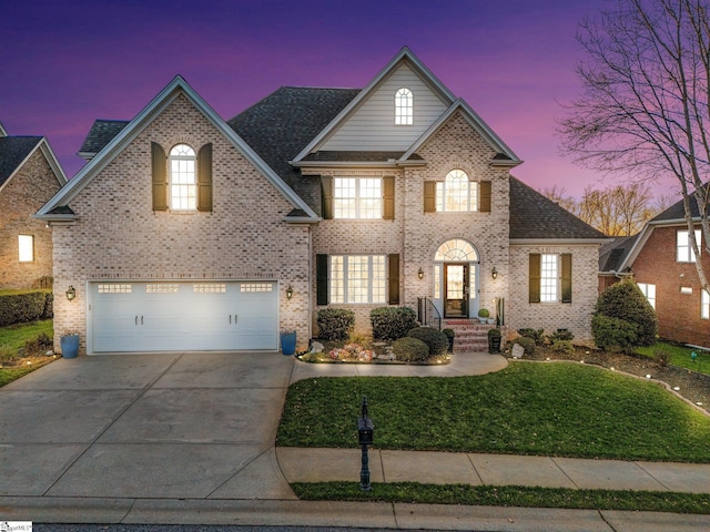 view of front of home featuring a lawn and a garage