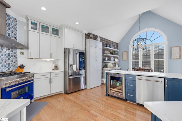 kitchen featuring white cabinets, hanging light fixtures, wine cooler, decorative backsplash, and stainless steel appliances