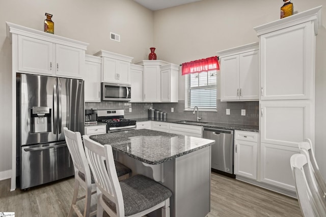 kitchen featuring sink, white cabinets, dark stone counters, and appliances with stainless steel finishes