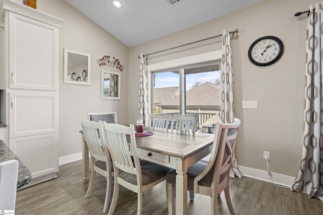 dining area featuring vaulted ceiling and dark wood-type flooring