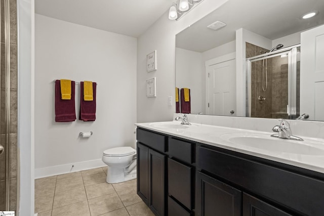 bathroom featuring toilet, vanity, tile patterned floors, and a shower with door