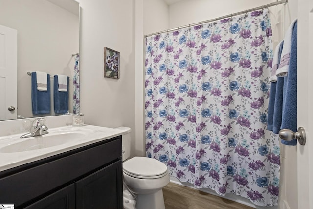 bathroom featuring hardwood / wood-style flooring, vanity, toilet, and walk in shower