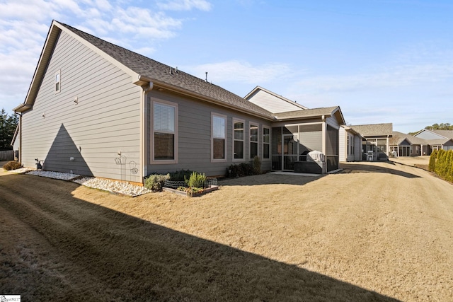 view of property exterior featuring a sunroom and a yard