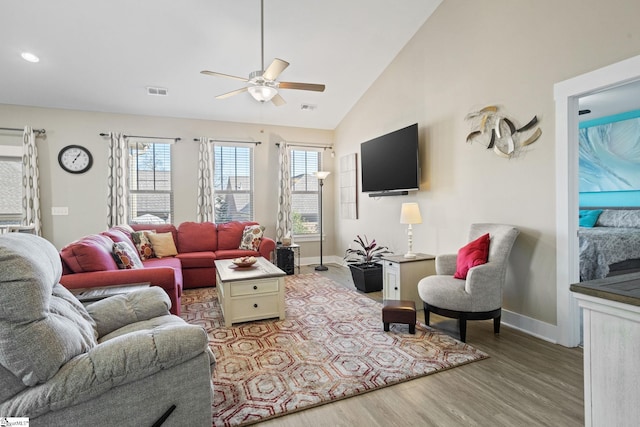 living room with light hardwood / wood-style floors, vaulted ceiling, and ceiling fan