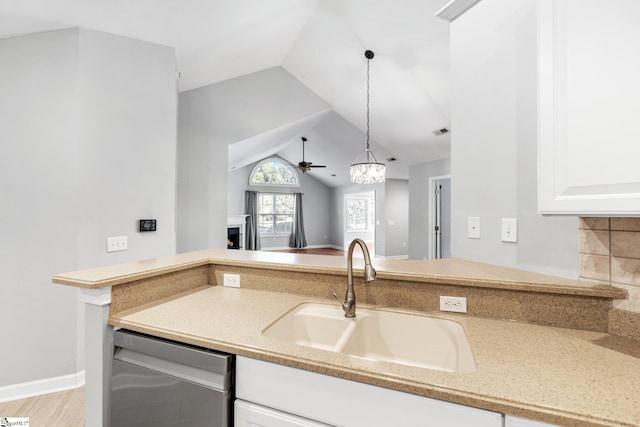 kitchen with tasteful backsplash, stainless steel dishwasher, vaulted ceiling, ceiling fan, and sink