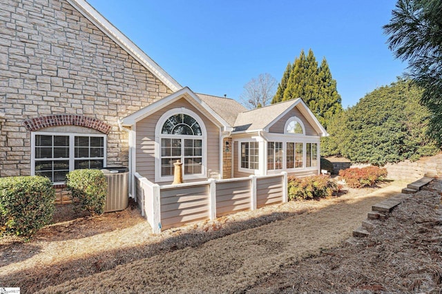 view of side of property featuring central AC and a sunroom