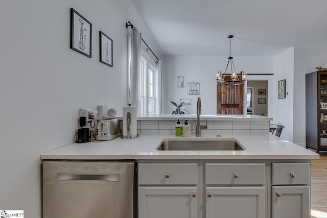 kitchen featuring sink, decorative light fixtures, gray cabinets, dishwasher, and a chandelier