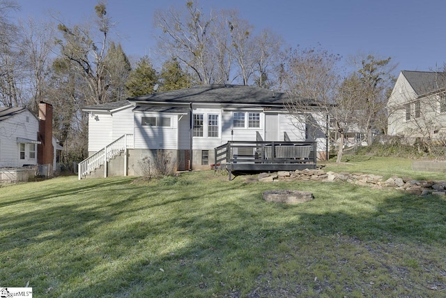 rear view of property featuring a lawn and a deck