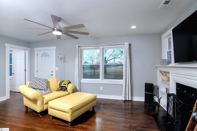 living room featuring ceiling fan and dark wood-type flooring