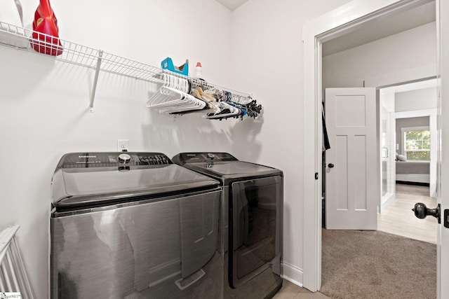 laundry room featuring light colored carpet and washer and dryer