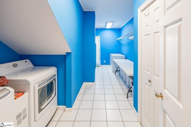 laundry area featuring washing machine and clothes dryer and light tile patterned flooring