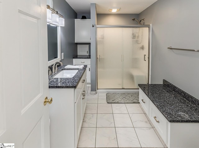 bathroom with vanity and a shower with door