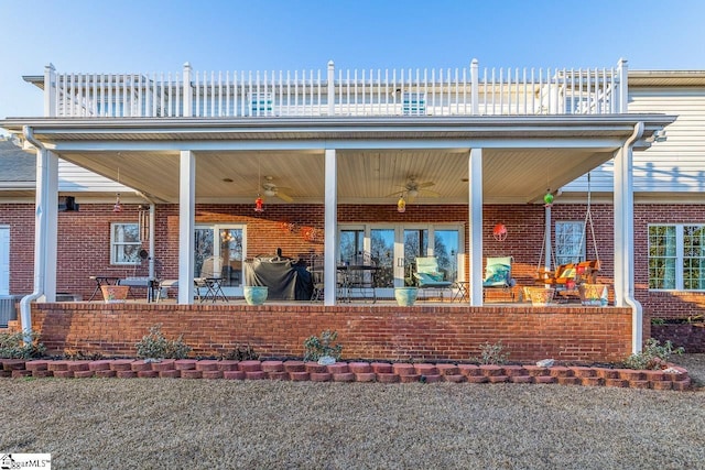 rear view of house with ceiling fan, a balcony, and a patio