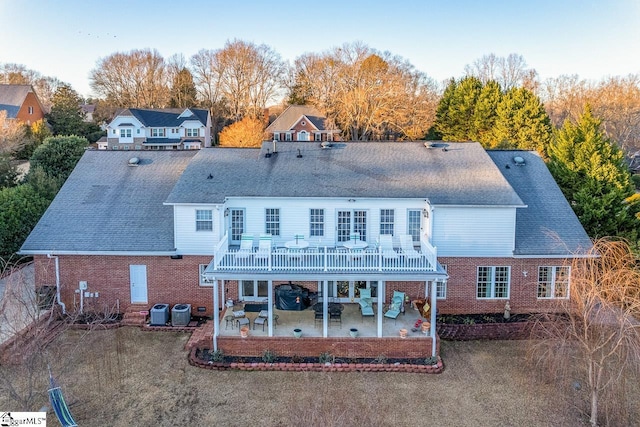 rear view of house with central AC and a patio area