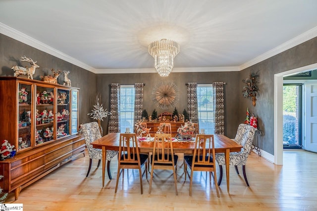 dining space with crown molding, light wood-type flooring, and an inviting chandelier