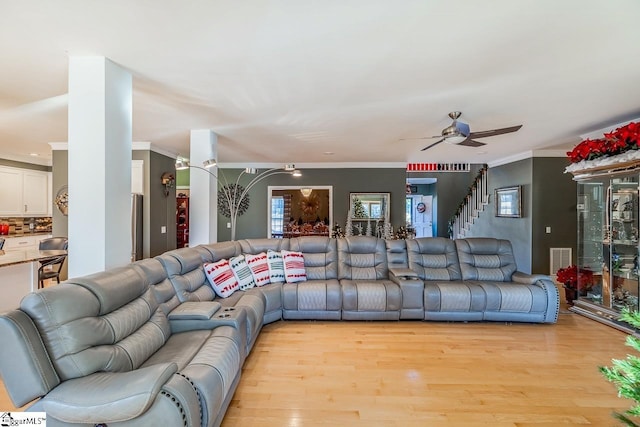 living room featuring crown molding, ceiling fan, and light hardwood / wood-style floors