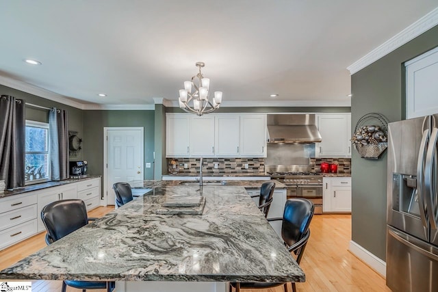 dining room with a notable chandelier, light hardwood / wood-style floors, ornamental molding, and sink