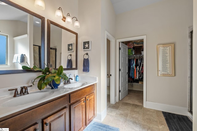 bathroom with vanity, a shower with door, and lofted ceiling