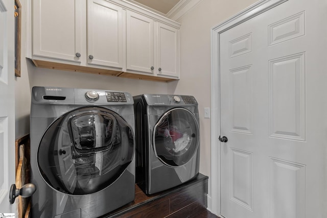 laundry room featuring cabinets, washing machine and dryer, dark hardwood / wood-style floors, and ornamental molding