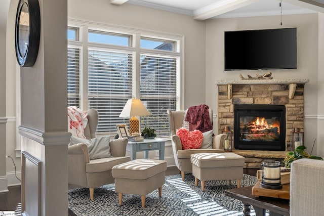 sitting room featuring wood-type flooring, a stone fireplace, and crown molding